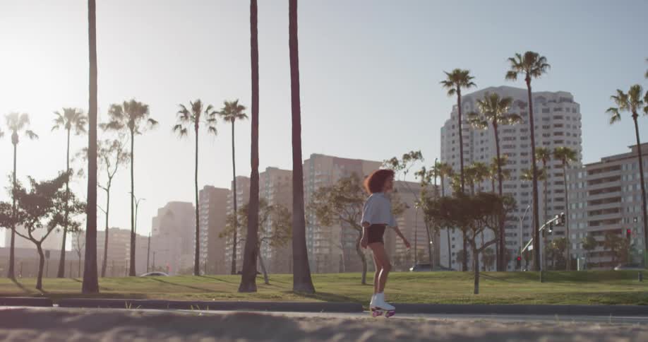 A woman skates in a coastal city on a sunny day
