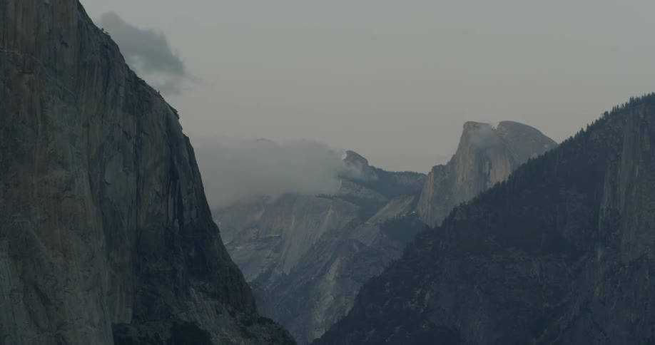 Clouds float above mountains at dusk