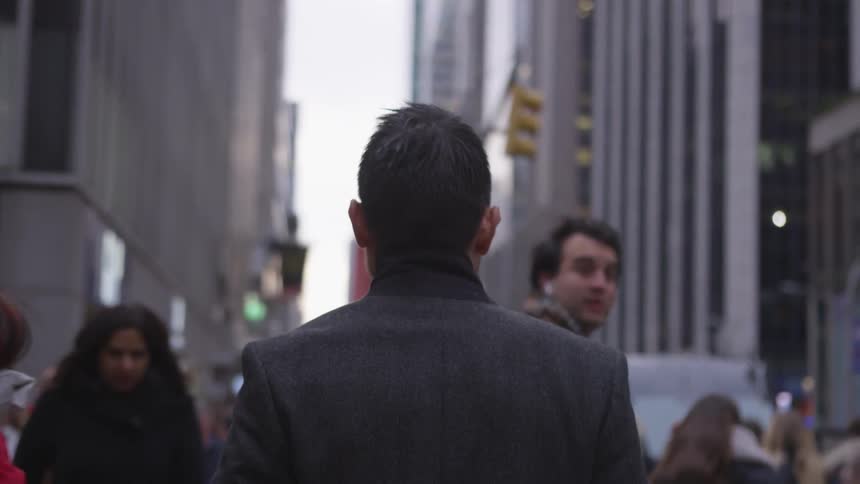 Pedestrians walk on a city sidewalk