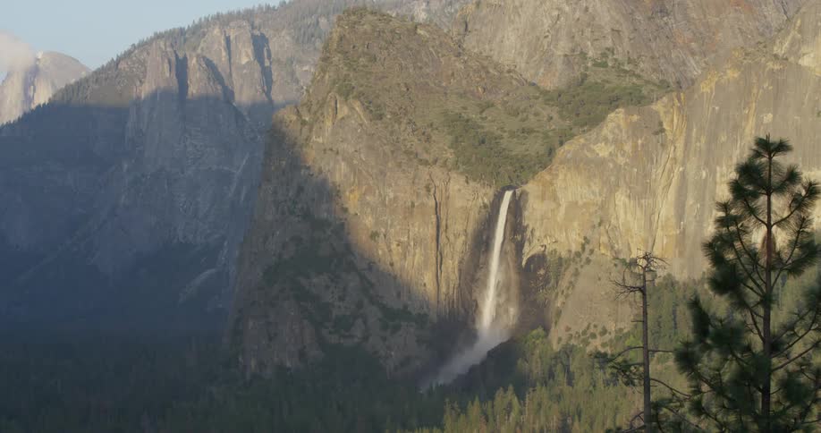 A waterfall flows over a cliff in the wilderness