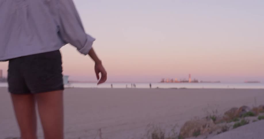 A woman roller skates near the beach