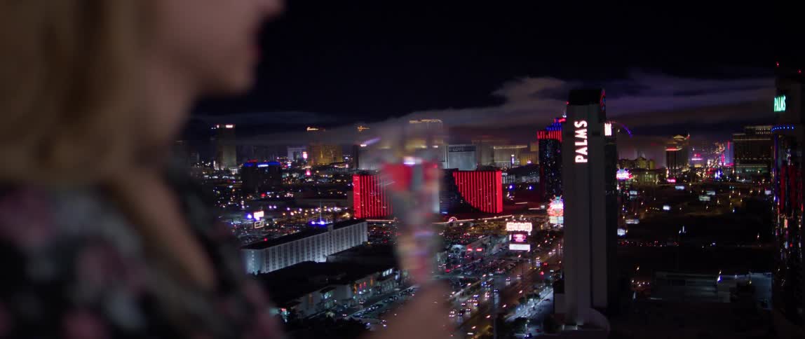 A woman drinks champagne in las vegas at night