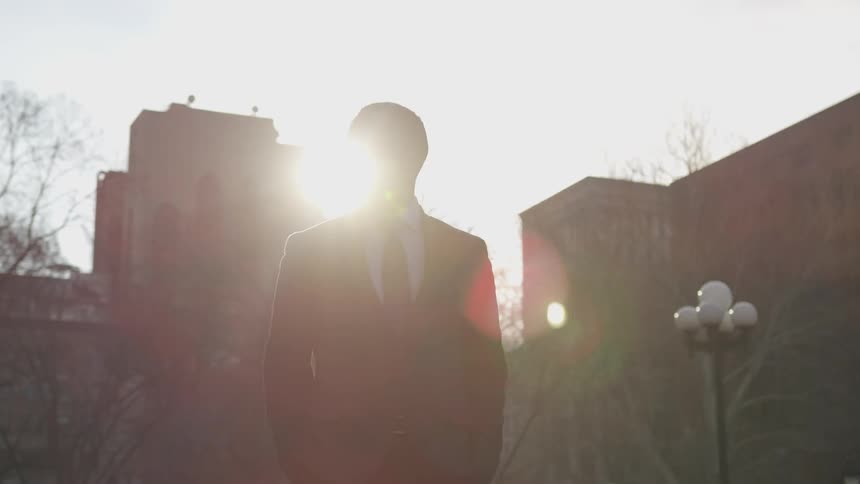 A man walks slowly on a cloudy day