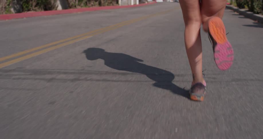 A woman jogs on a paved road
