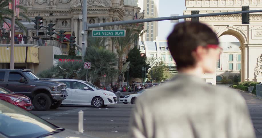 Woman stands on a city street looking over