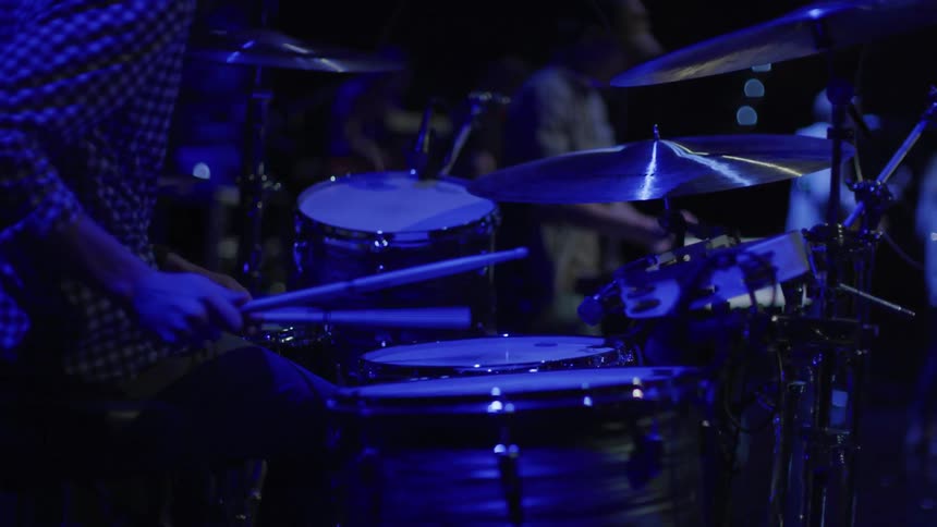 A man plays backup drums for a band