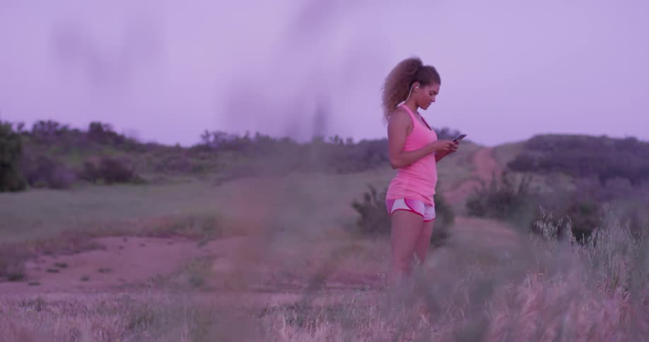 Woman is outside in the evening and using her phone