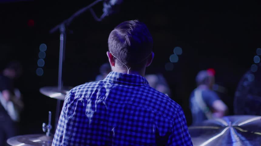 A drummer and band play on stage
