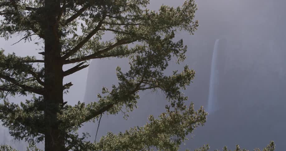A waterfall flows over a cliff in the wilderness