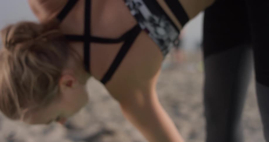 A woman does yoga on a beach