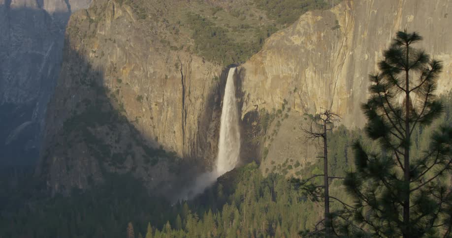A waterfall flows over a cliff in the wilderness