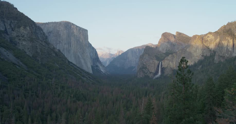 A waterfall flows over a cliff in the wilderness