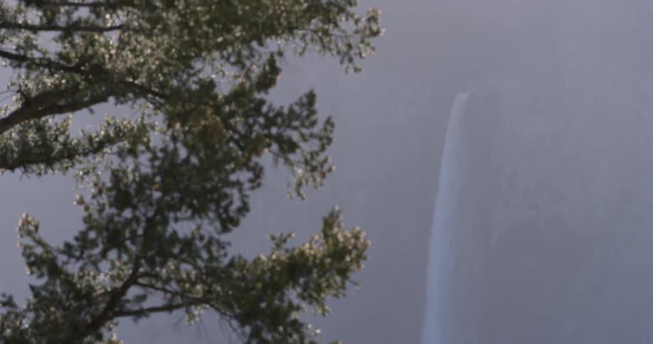 A waterfall flows over a cliff in the wilderness