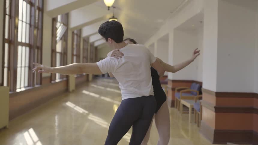 Man and woman dance together in a sunny hallway