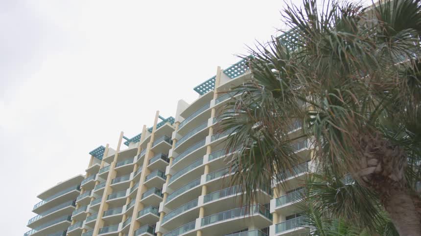 A large hotel building with trees in front of it at day time