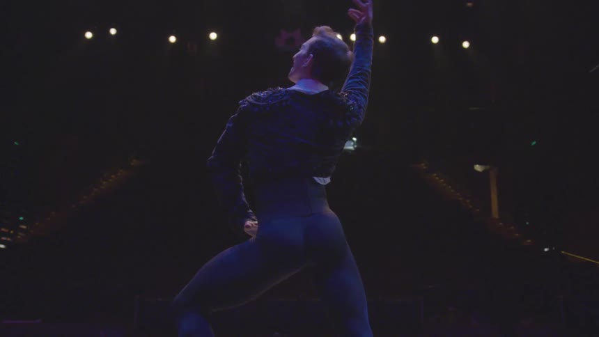 Man dances on a stage at night