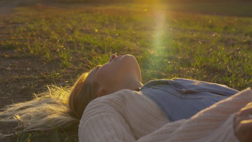 A woman is resting in the grass