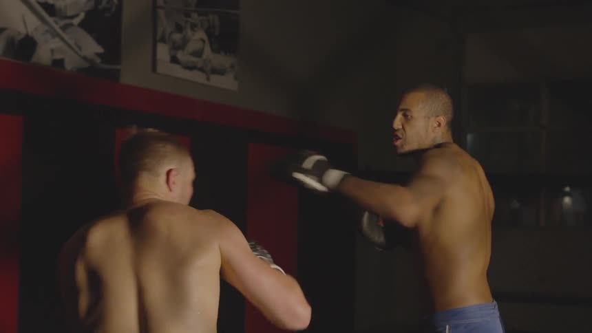 Two boxers spar in a gym
