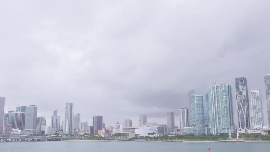 Clouds pass over a large city and body of water