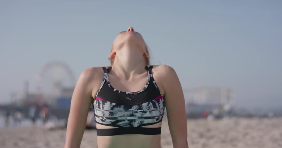 A woman does yoga on the sunny beach