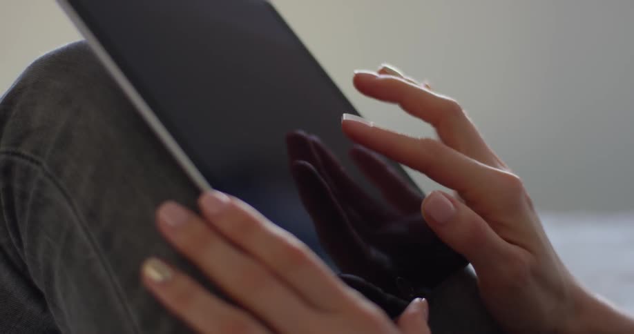 A woman scrolls on a tablet