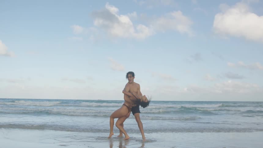 A couple dance and dip on the beach