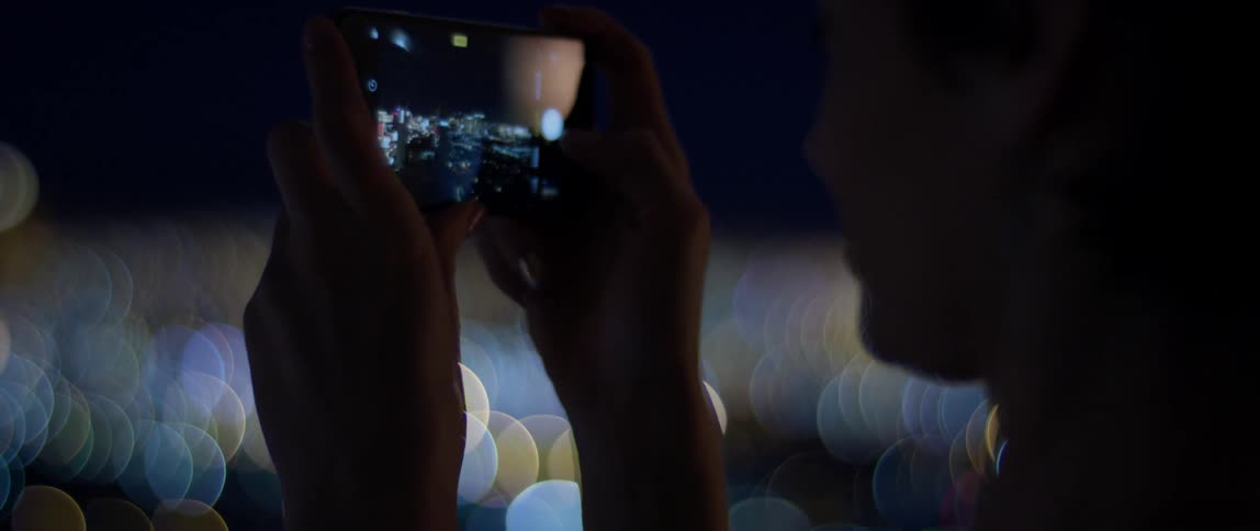 Woman takes a picture of the city at night