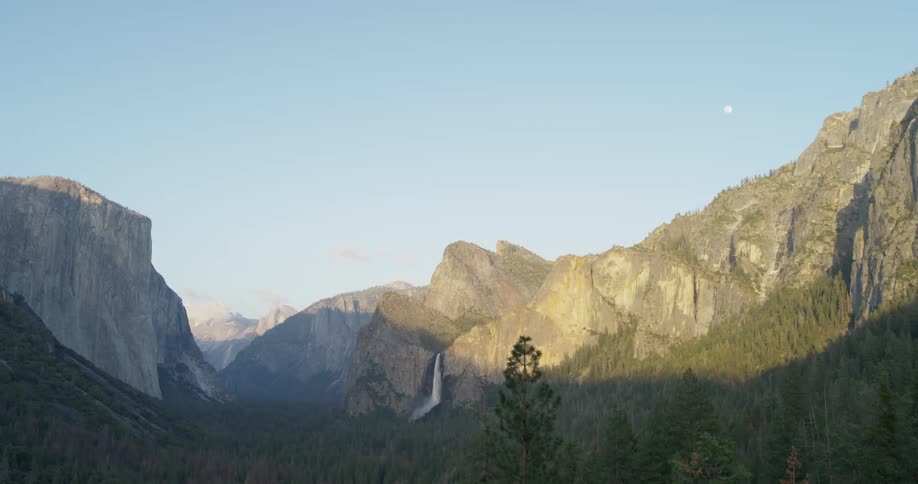A waterfall flows over a cliff in the wilderness