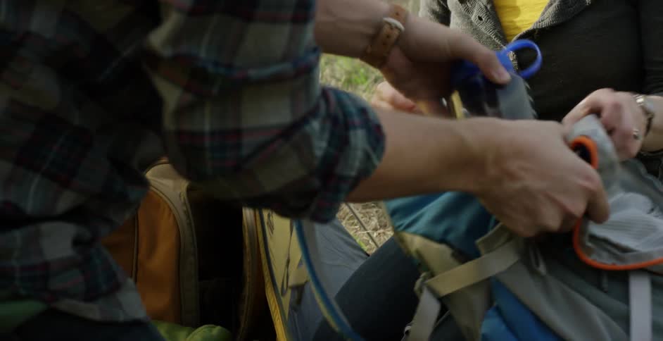 A man and woman pack their bags and talk