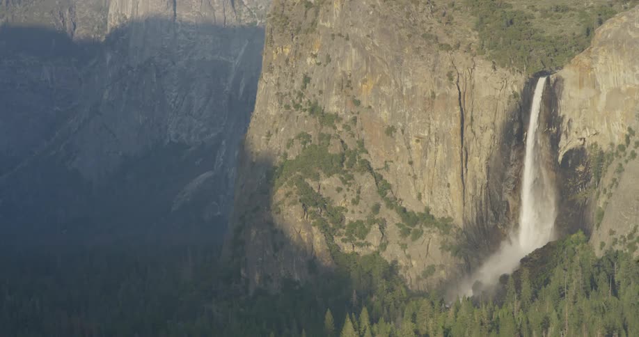 A waterfall flows over a cliff in the wilderness