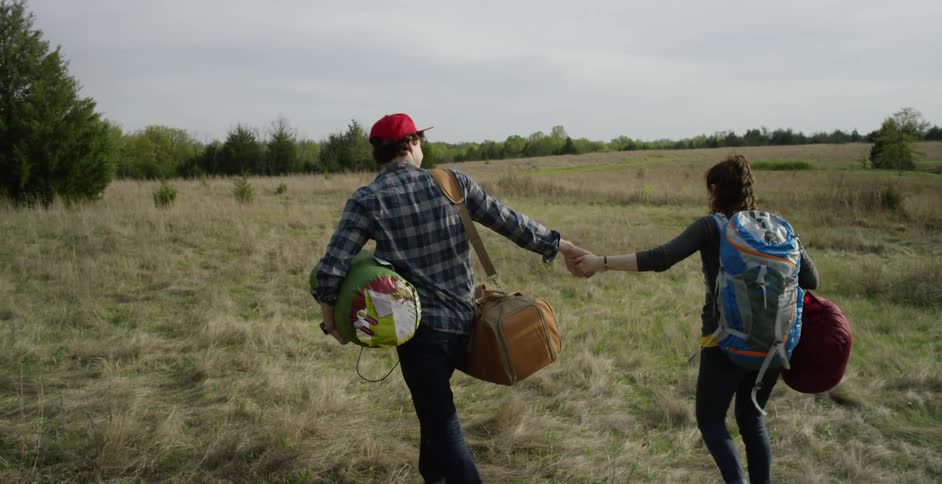 A couple walk on the grass and kiss