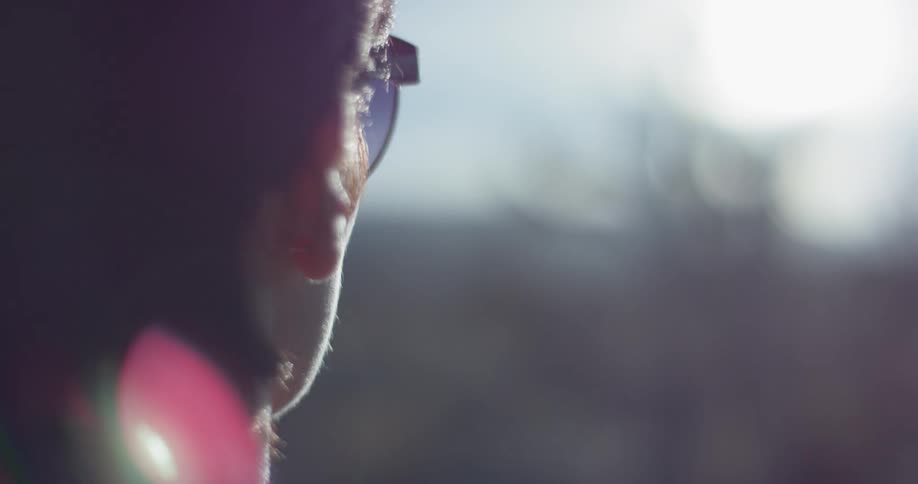 A woman puts on her sunglasses on a sunny day