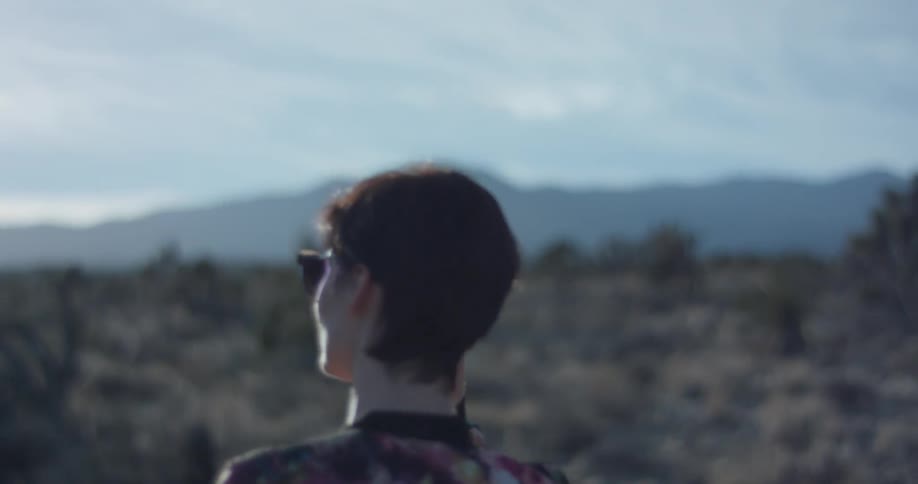 A woman walks alone in a desert