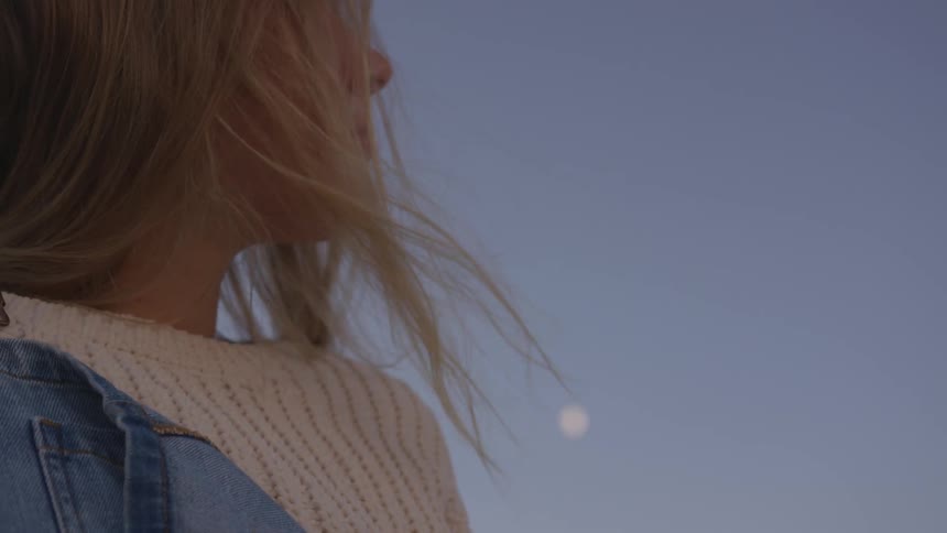 The wind blows the woman's hair on a sunny day