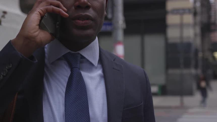 A man talks on his phone while walking