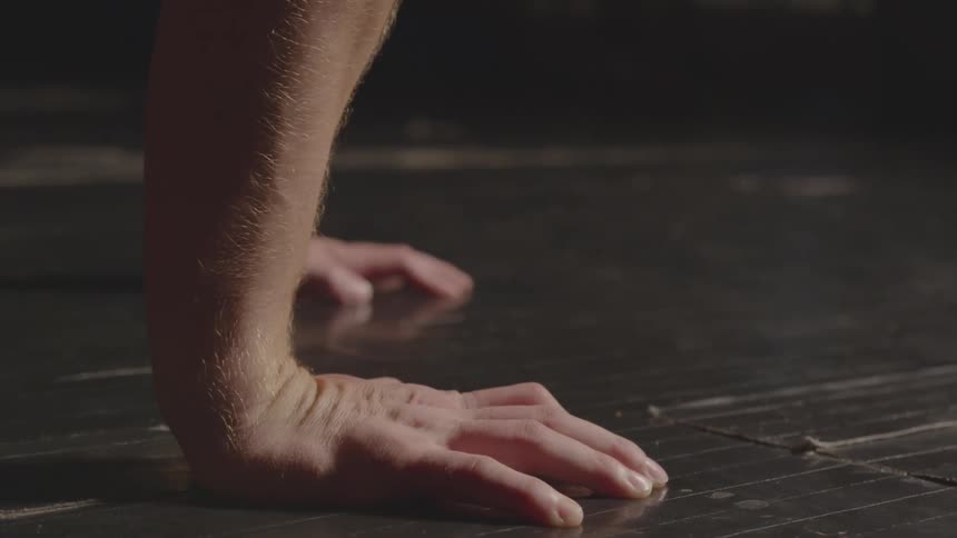 A shirtless man does push ups