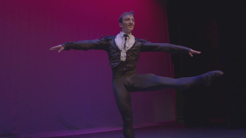A male ballerina spins on the stage