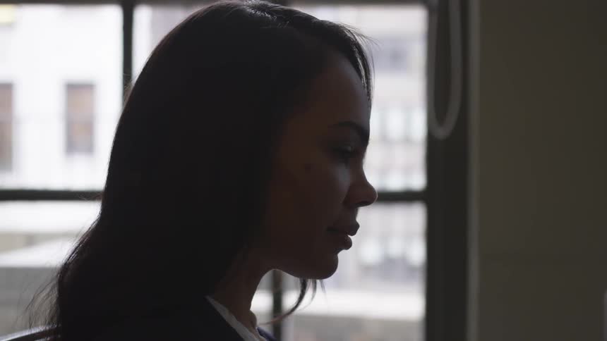 A woman is near the window in her home