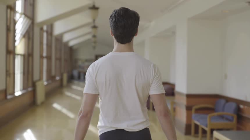 A man slowly steps down the hall
