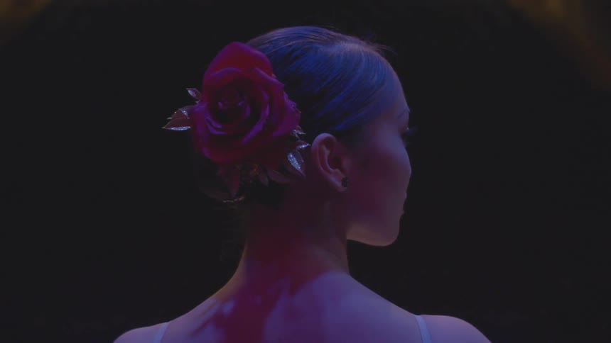 A woman has a rose in her hair