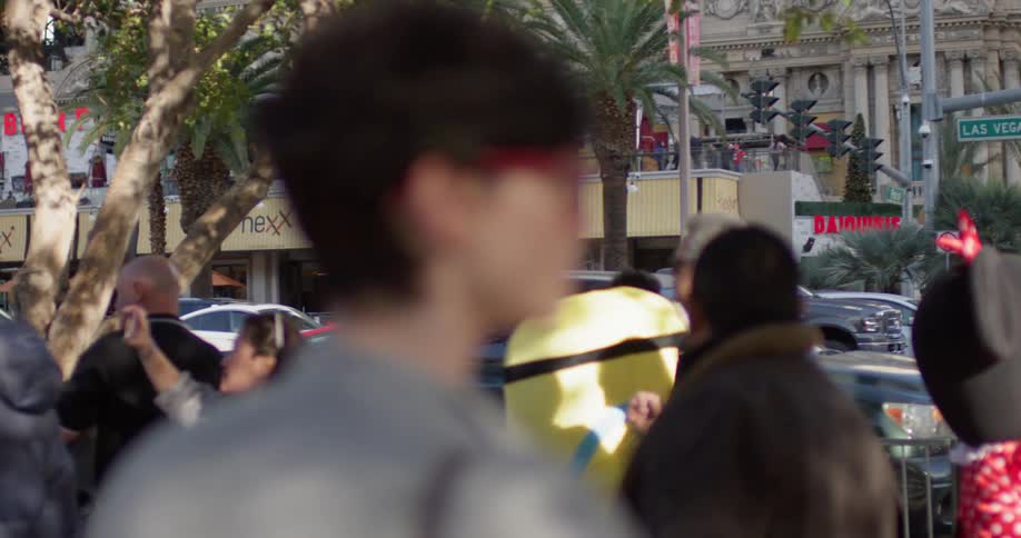 Woman in red glasses watches the people walk by as she stands in the city