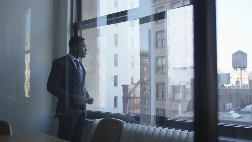 A man looks out the window thinking