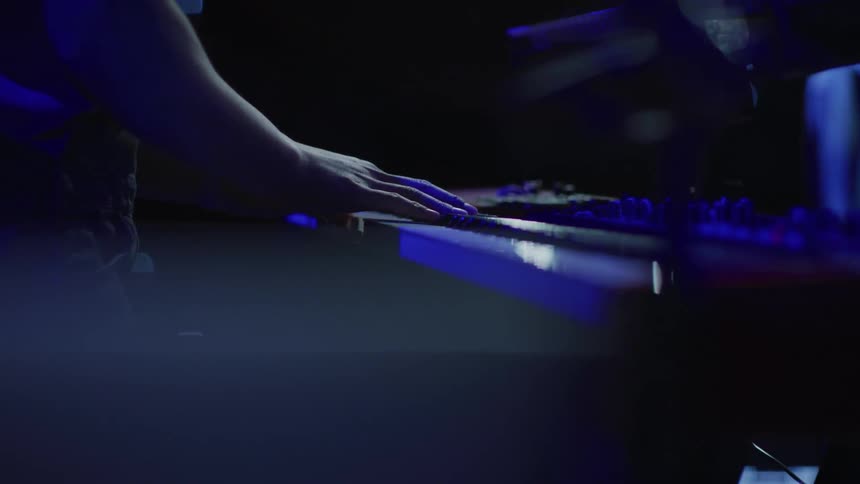 A man plays a keyboard on stage