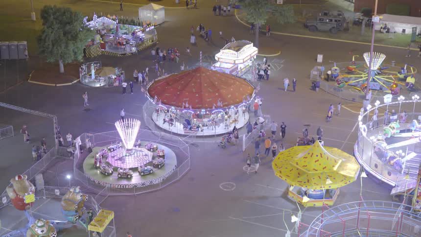 People walk around the rides and grounds of a carnival