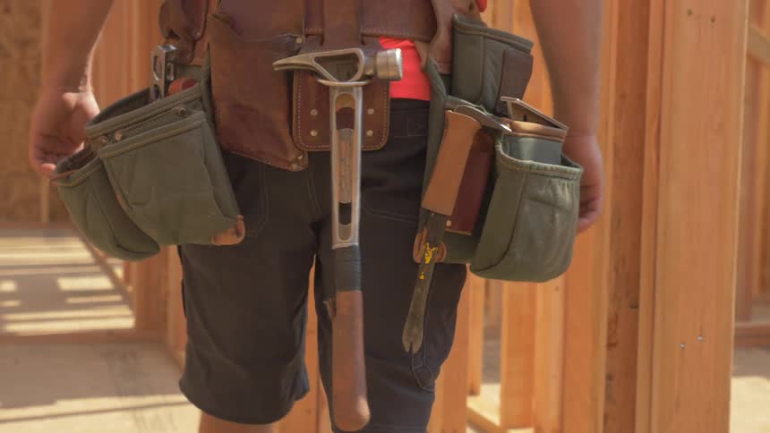 Construction worker is walking through house being built
