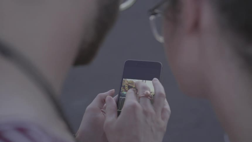 The man is showing a woman photos on his phone