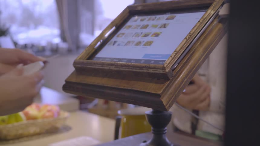 The person is using a register to sell goods