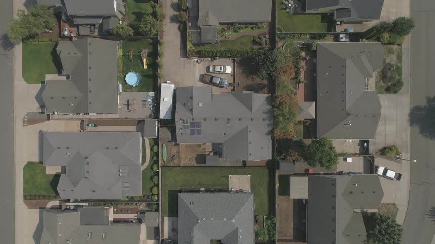 Rooftops, driveways and yards of homes in a neighborhood