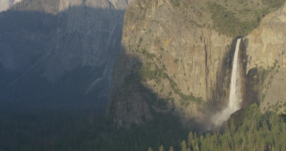 Large waterfall splashes down a mountain near trees