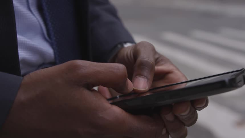 A man is typing on his phone